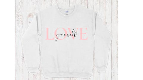 White crewneck sweatshirt with "love yourself" quote in pink and black lettering