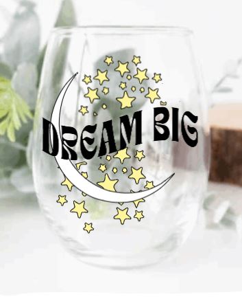Stemless wine glass with moon and stars graphic and "dream big" quote